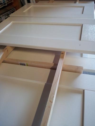 From CREAM to WHITE - Kitchen cabinet doors, removed, prepared and re-sprayed, from Country Cream to High Gloss White. New contemporary brushed steel handles fitted.